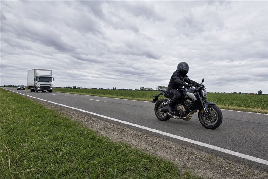 Un motard circule devant un camion