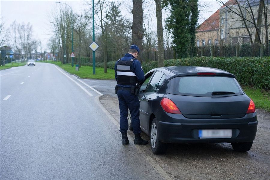 Conducteur présentant son permis de conduire à un agent qualifié qui rédige un procès-verbal
