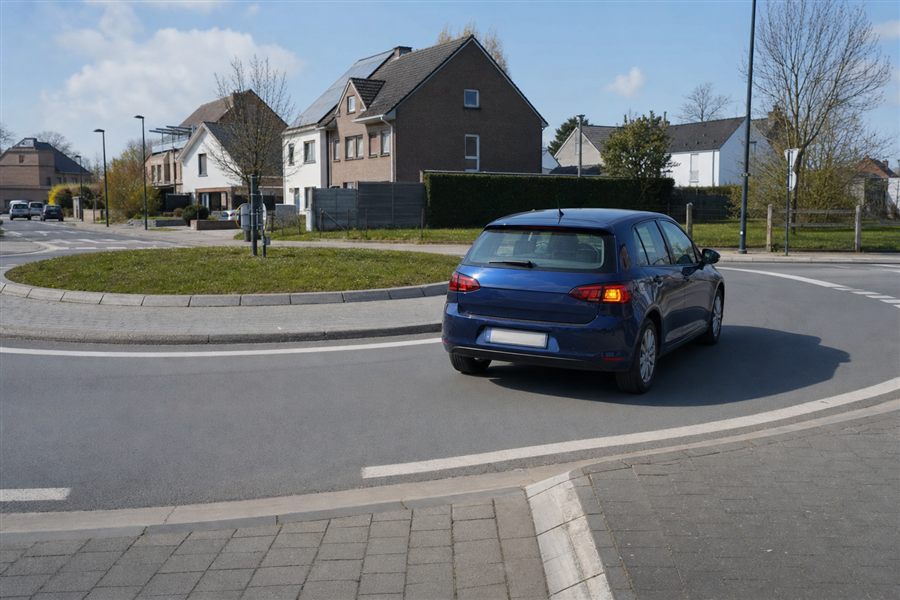 Voiture dans l'anneau d'un rond-point, clignotant droit allumé pour prendre sa sortie