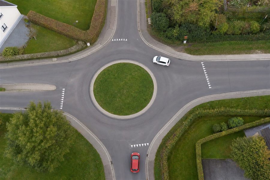 Vue aérienne d'un rond-point à quatre branches, triangles de cédez-le-passage à chaque entrée