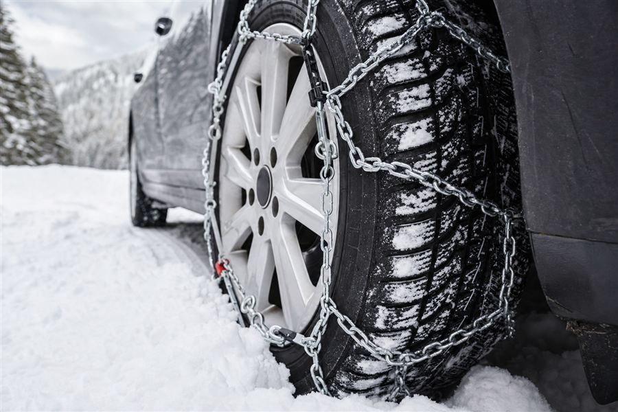 Voiture équipée de chaînes antidérapantes sur une route enneigée