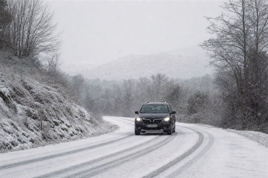 Voiture sportive projetant de la neige sur une route enneigée