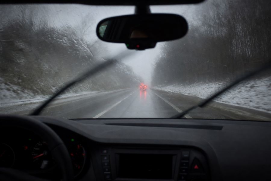 Vue depuis l'habitacle d'une voiture roulant sous la pluie et la neige