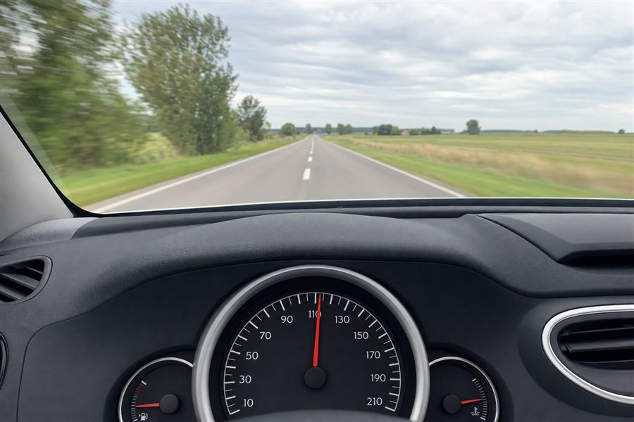 Voiture roulant sur une route de campagne sous un volant avec compteur de vitesse
