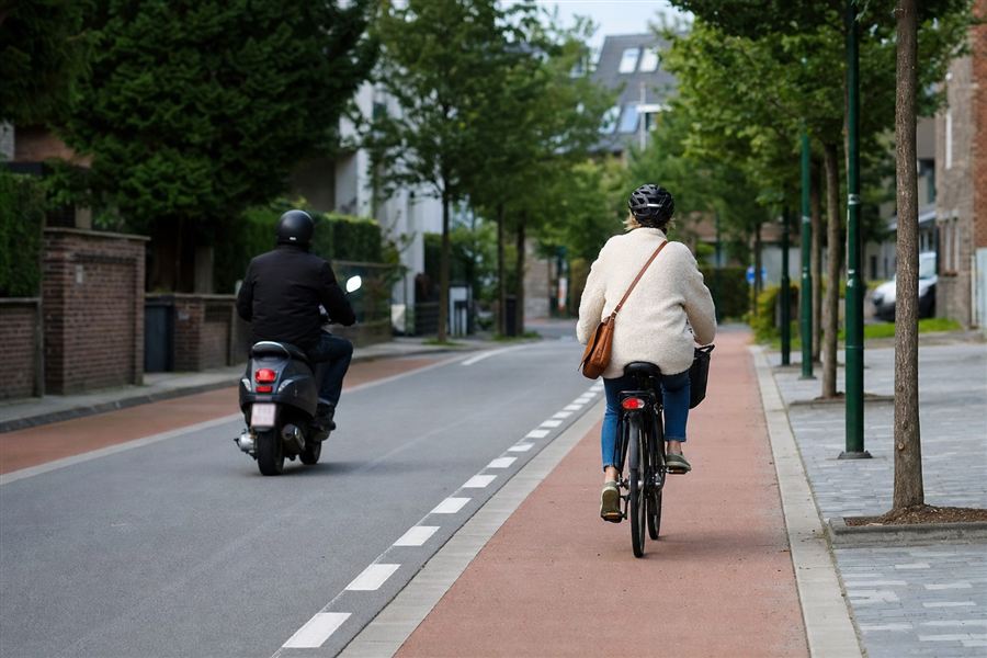 Un cyclomoteur et un cycliste circulant sur la chaussée