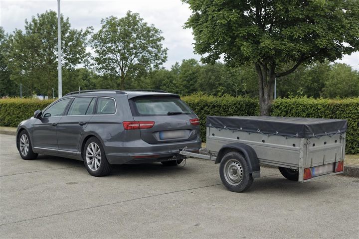 Voiture break attelée à une remorque légère bâchée