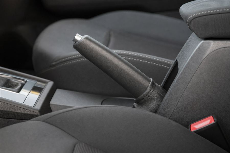 Conducteur qui serre le frein à main avant de quitter son véhicule