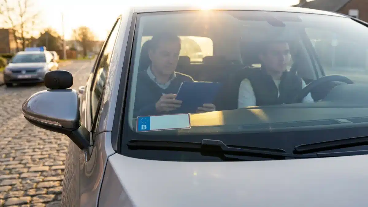 Un candidat au permis B conduit un véhicule auto-école lors de l'examen pratique sur une route belge.